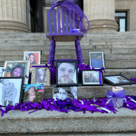A series of framed photos of people who have died from overdoses were perched on the steps of the Manitoba Legislature to mark Overdose Awareness Day. (Alana Cole/CBC)
