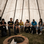 Members of the UM campus community gather inside a tipi