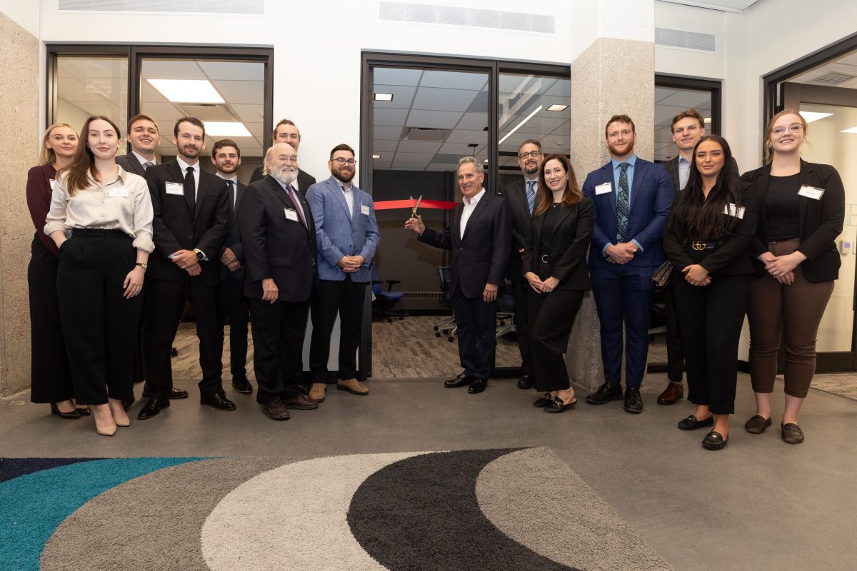 UM Alum L. Kerry Vickar [LLB/1980] (centre) officially opens the business law clinical space named in his honour surrounded by law students; clinical instructors Nick Slonosky [BComm/1976; LLB/1979] and Yvan Larocque (left of door); Dr. Richard Jochelson, Dean of Law and Stephanie Levene [BA/1999; BComm/2022; MBA/2008], Associate VP (Alumni and Donor Relations) (right of Vickar). Photo by Mike Latschislaw.