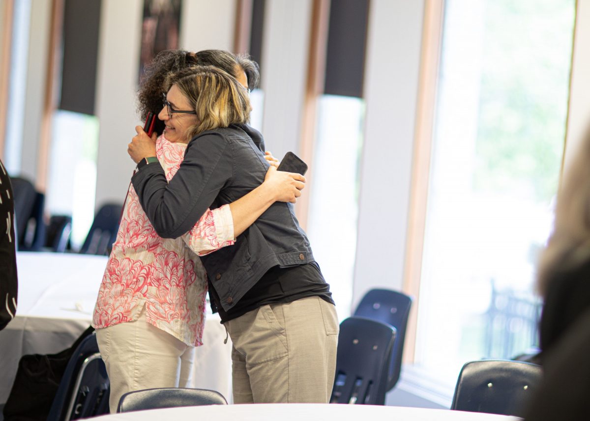 Two attendees of the 2023 SoTL Symposium embrace.