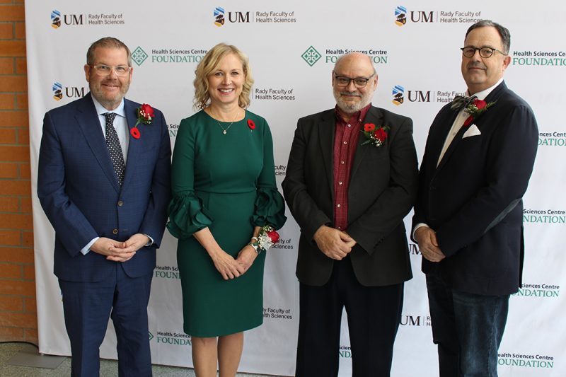 Jonathon Lyon, Jacquie Ripat, Reg Urbanowski and Peter Nickerson stand in front of a banner with logos for the Rady Faculty of Health Sciences at the University of Manitoba and the HSC Foundation.