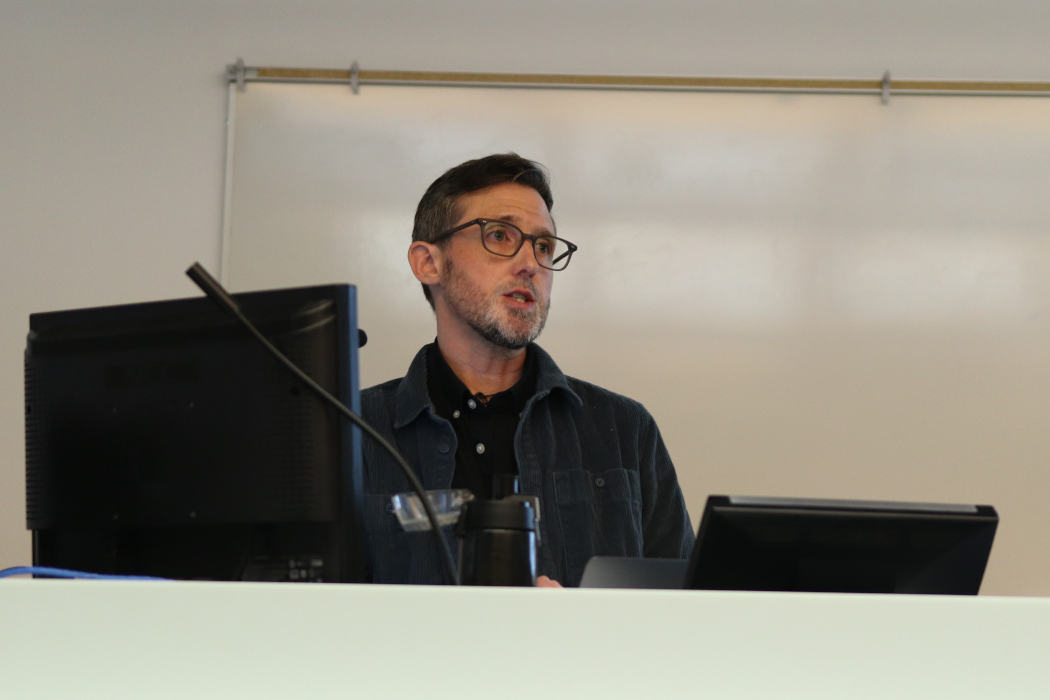 Dr. Jake Pyne speaks at a lectern.