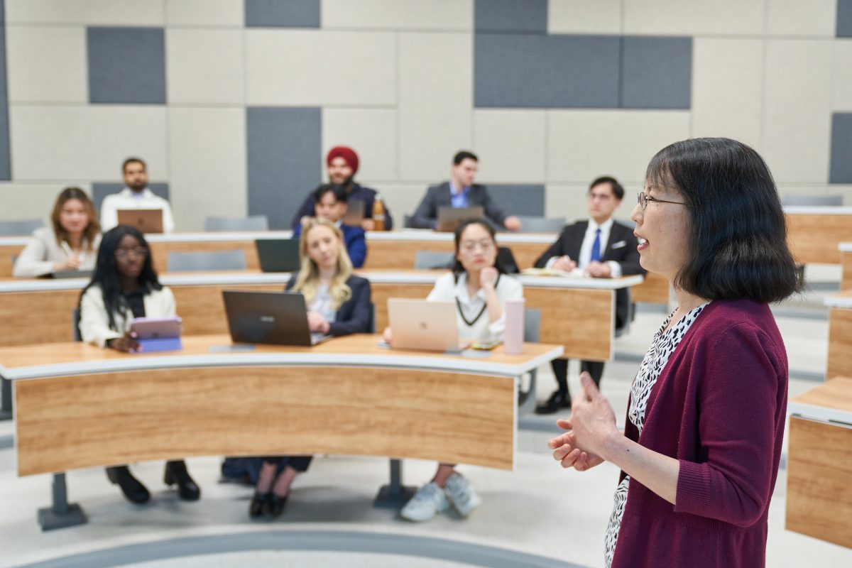 an instructor gives a lecture to business students in a classroom