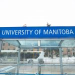 outdoor image of blue bus stop signage at fort garry campus that reads university of manitoba
