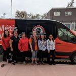 Six health-care workers stand in front of a Manitoba Metis Federation van.