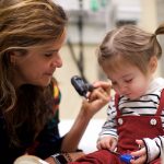 Physician examines toddler.