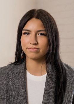 Photo of Trechelle Bunn, a young woman in a white t-shirt and grey suit jacket with long black hair and a calm, professional look of confidence.