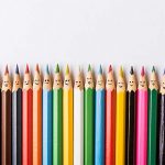 A row of many coloured pencils with faces on them.
