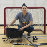 Christina Keeper crouching in front of a hockey net.