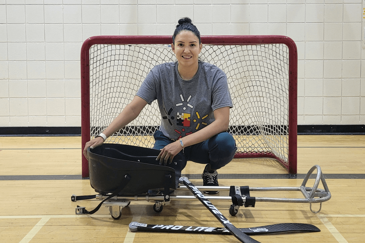Christina Keeper crouching in front of a hockey net.