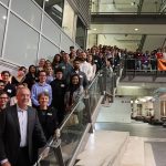 Dr. Gerry Price stands on stairs with hundreds of scholarship winners
