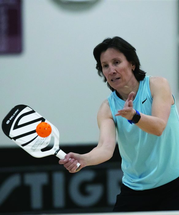 Sandra Webber hitting a ball with a racquet during a game of pickleball.