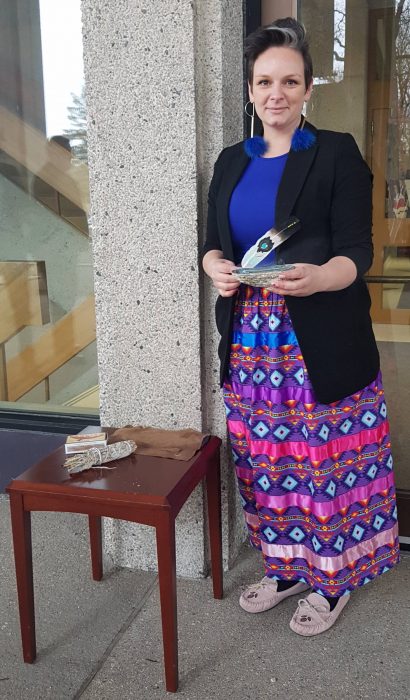 MILSA VP Internal Métis, Melinda Moch, prepares to greet the Justice with a smudge at the entrance of Robson Hall.
