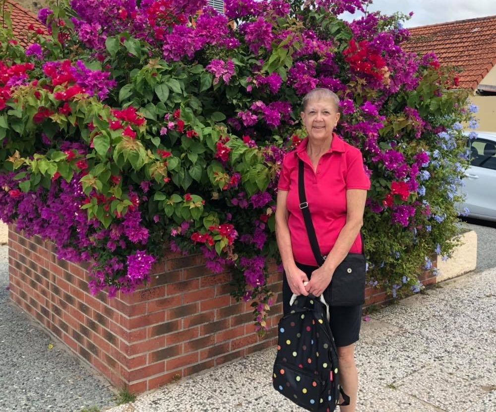 An image of Julie Mikuska standing in front of flowers.