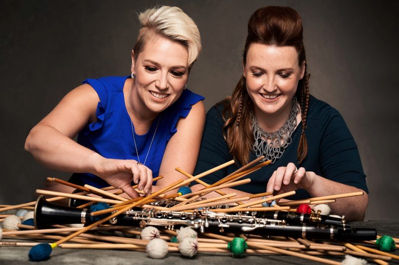 Tori Sparks and Catherine Wood look at a pile of mallets and clarinets.