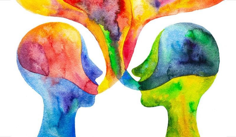 Watercolour painting of two heads facing each other with flowing language bubbles coming out of their mouths. Colours include blues, yellows, oranges, and reds.