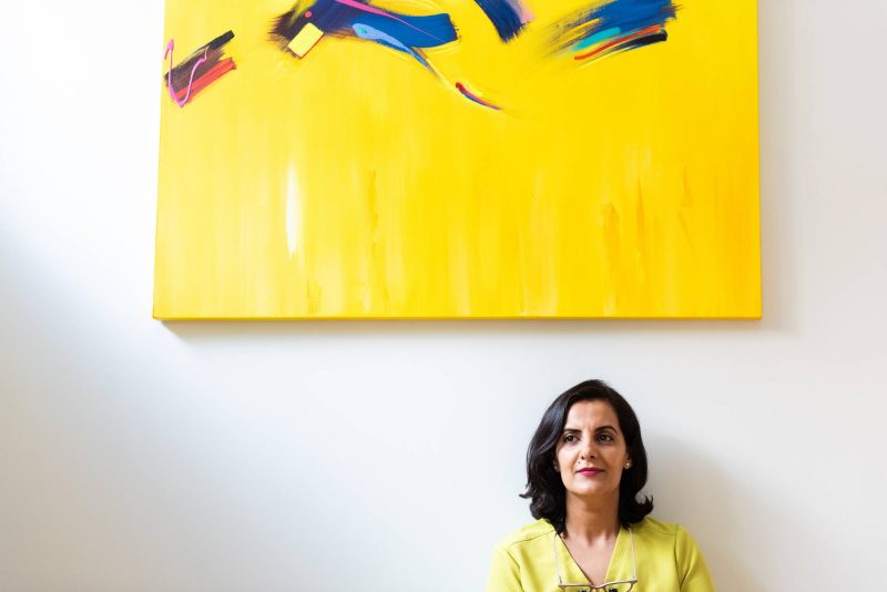 Huma Sharief is pictured in her condo, below a large yellow abstract painting