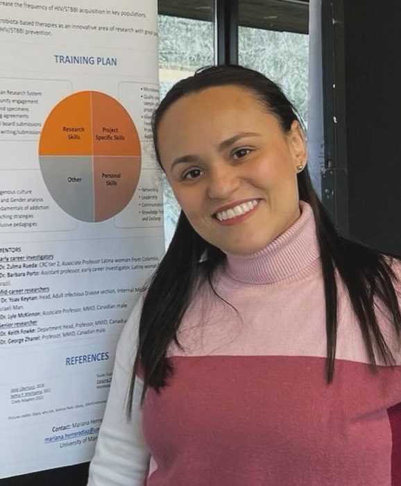 Mariana Herrera Diaz in front of a research poster.