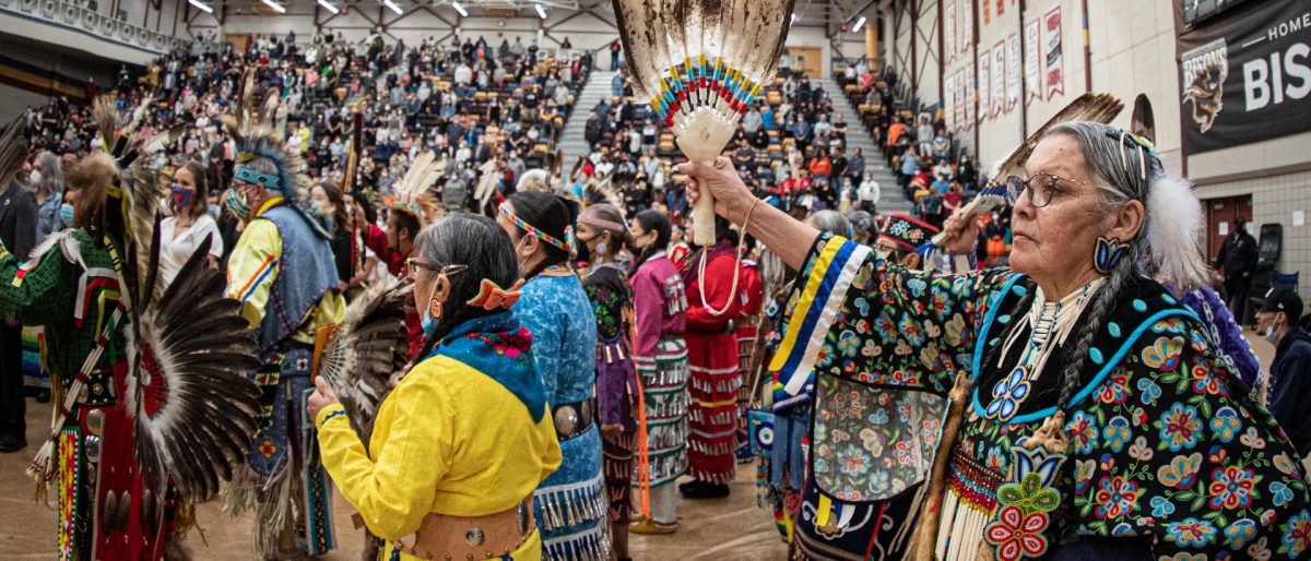 A group of pow wow dancers in colourful regalia.