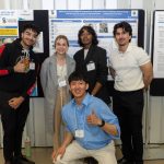 Students posing in front of poster during Research Day 2024