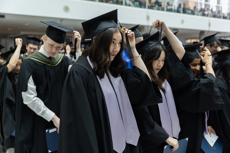 Graduating students move their tassels to the left at a convocation ceremony.