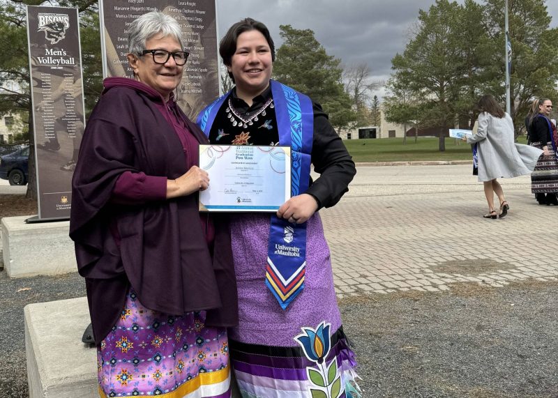 Mom with Indigenous graduate wearing graduation stole and holding certificate