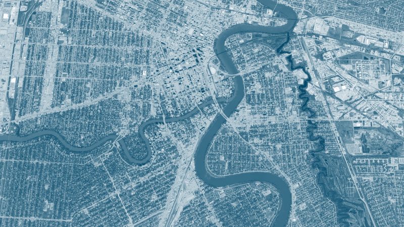 An aerial view of Winnipeg's downtown and rivers with a blue overlay filter.
