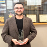 Dr. Rusty Souleymanov holding an Outstanding University of Manitoba Teacher Award