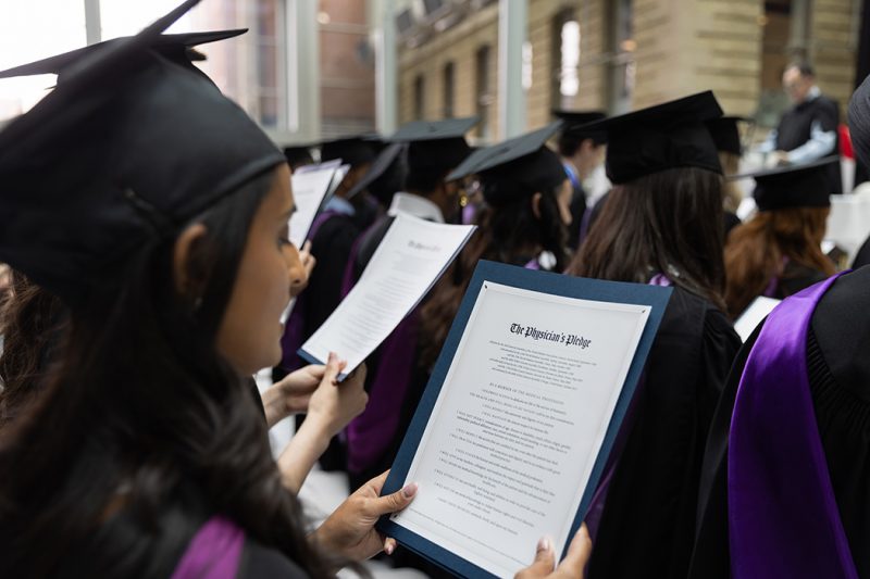 A graduate reads a physician's pledge at a convocation ceremony.