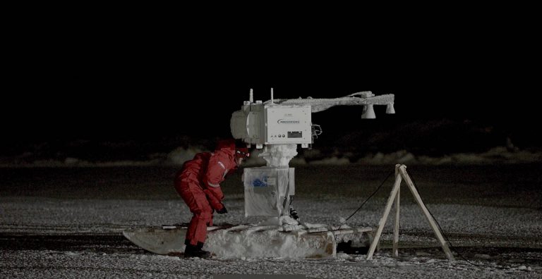 UM researcher Julienne Stroeve looking down at ice to measure thickness in Hudson Bay area.