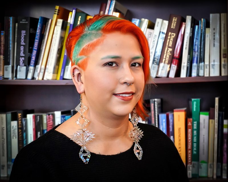 Headshot of Kaila Johnston, NCTR, standing in front of a bookcase
