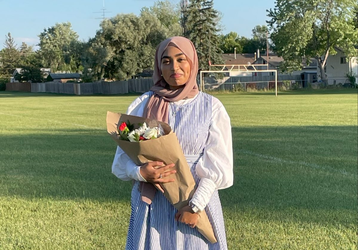 Photo of woman holding a bunch of flowers outside in the summer