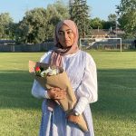 Photo of woman holding a bunch of flowers outside in the summer