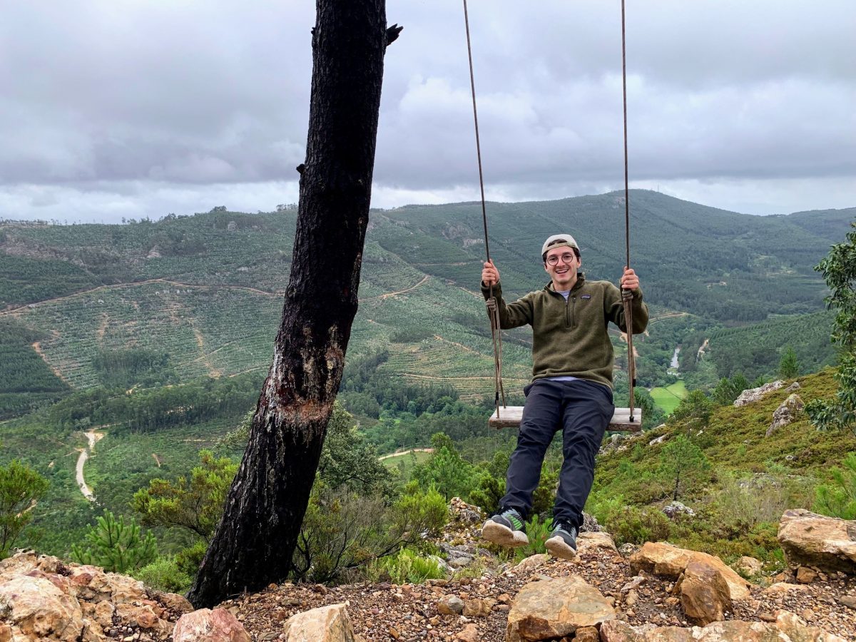 Martin Glikman is on a swing with a lush green valley in the background.