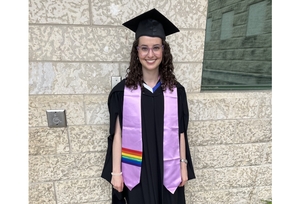 Chloe Vickar wears a lavender stole with Pride flag on it. She is also wearing a graduation cap and gown.