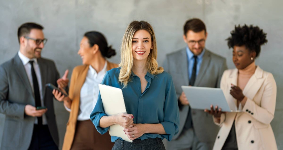 Photo of a professional woman holding her notes and standing in front of four business colleagues