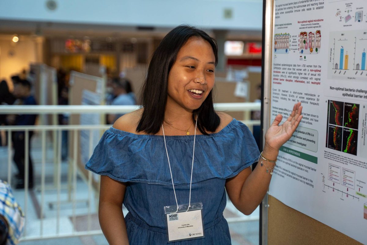 Camila Oda Jallime standing next to her research poster in brodie atrium