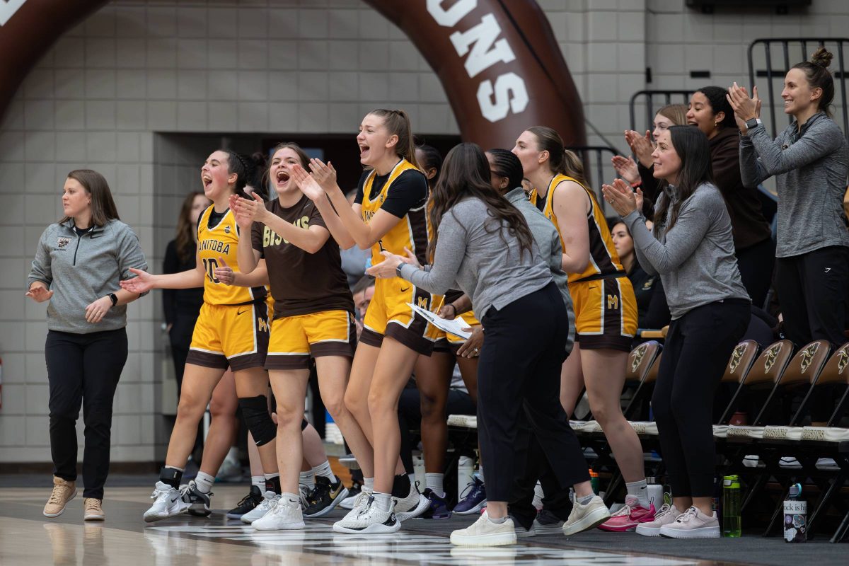 The Bisons women's volleyball team celebrates on the sidelines after a basket