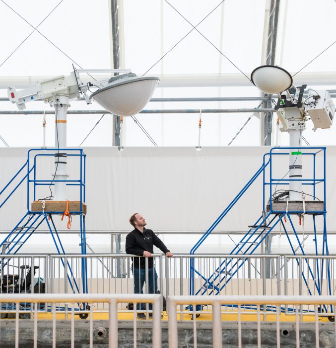 UM researcher is dwarfed by the large suspended sensory equipment at the Churchill Marine Observatory.