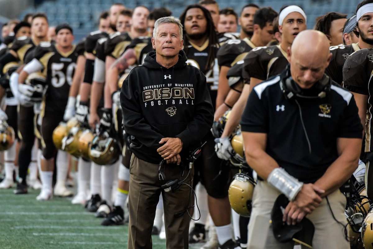 Brian Cobie stands alongside his players on the sidelines