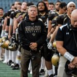 Brian Cobie stands alongside his players on the sidelines