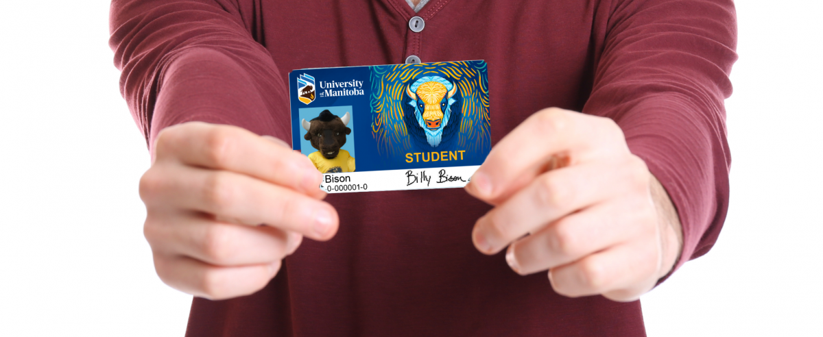 Student holding their ID card in front of them.