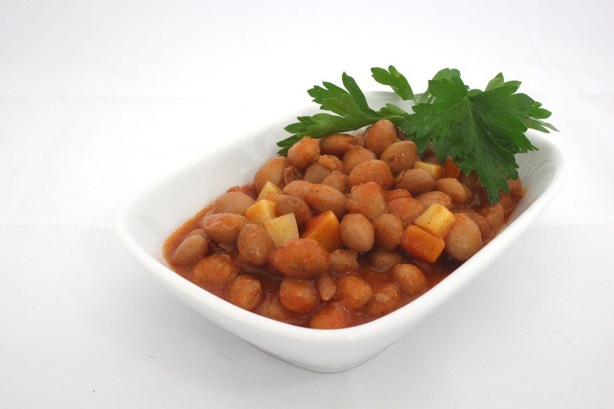 bowl of cooked kidney beans in a white serving dish on a white table