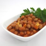 bowl of cooked kidney beans in a white serving dish on a white table