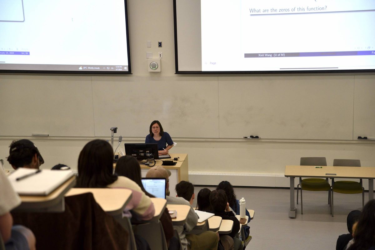 Instructor stands at the front of a classroom of students