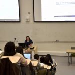 Instructor stands at the front of a classroom of students