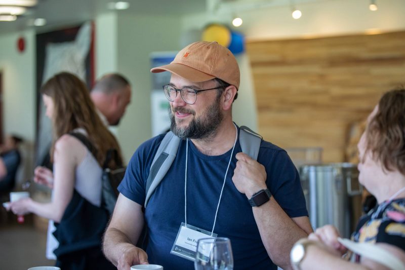 Person smiling while talking with other people in the hallway.