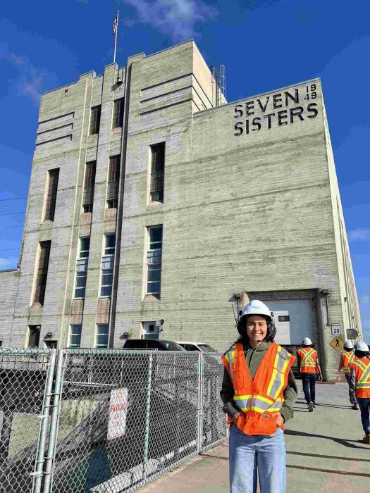 person in hard hat and safety vest standing in front of building