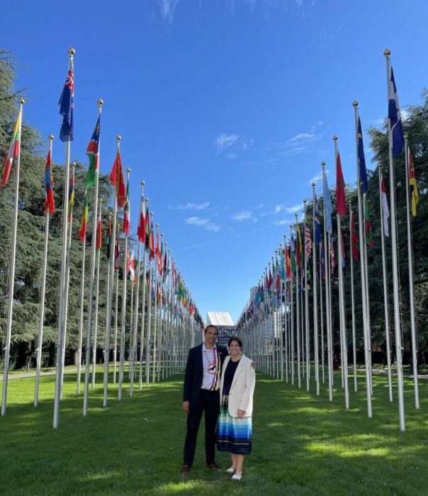 Tréchelle Bunn and fellow Youth Chief in front of UN flags