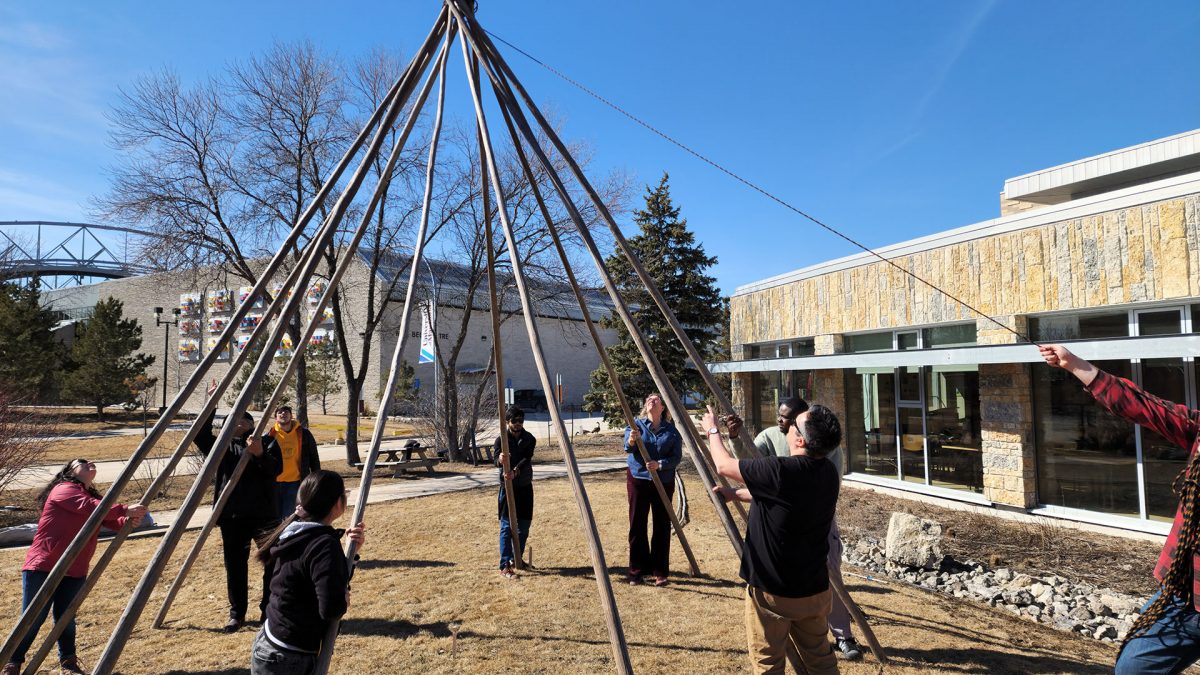 people building a Tipi outside